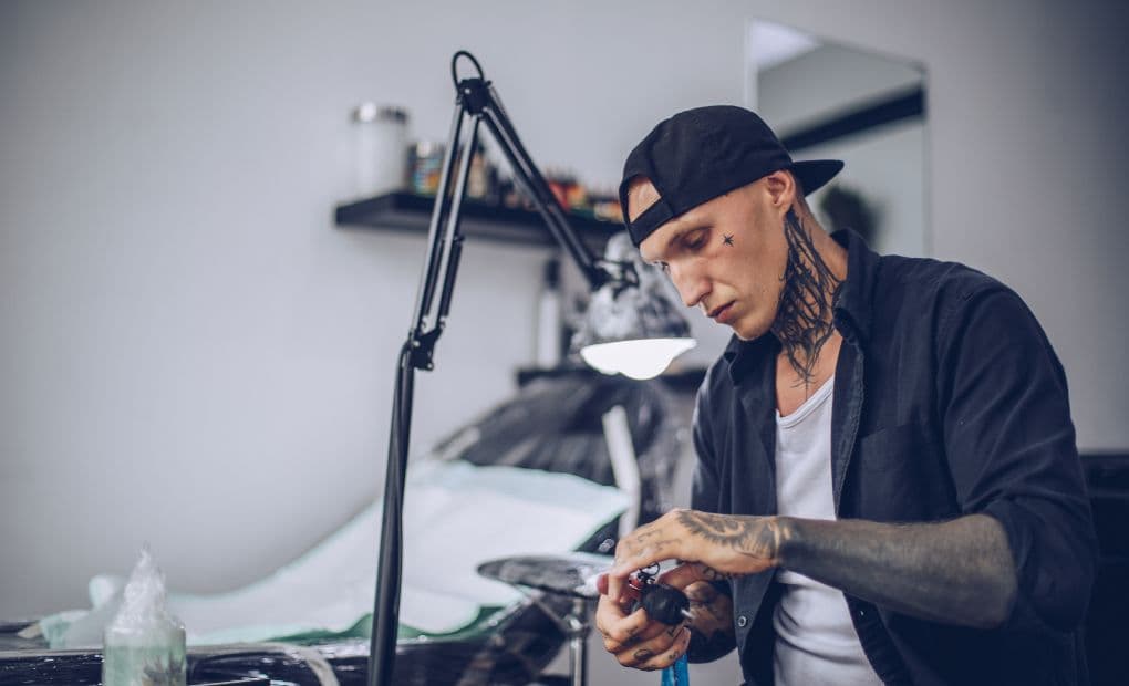 man sat in a tattoo studio