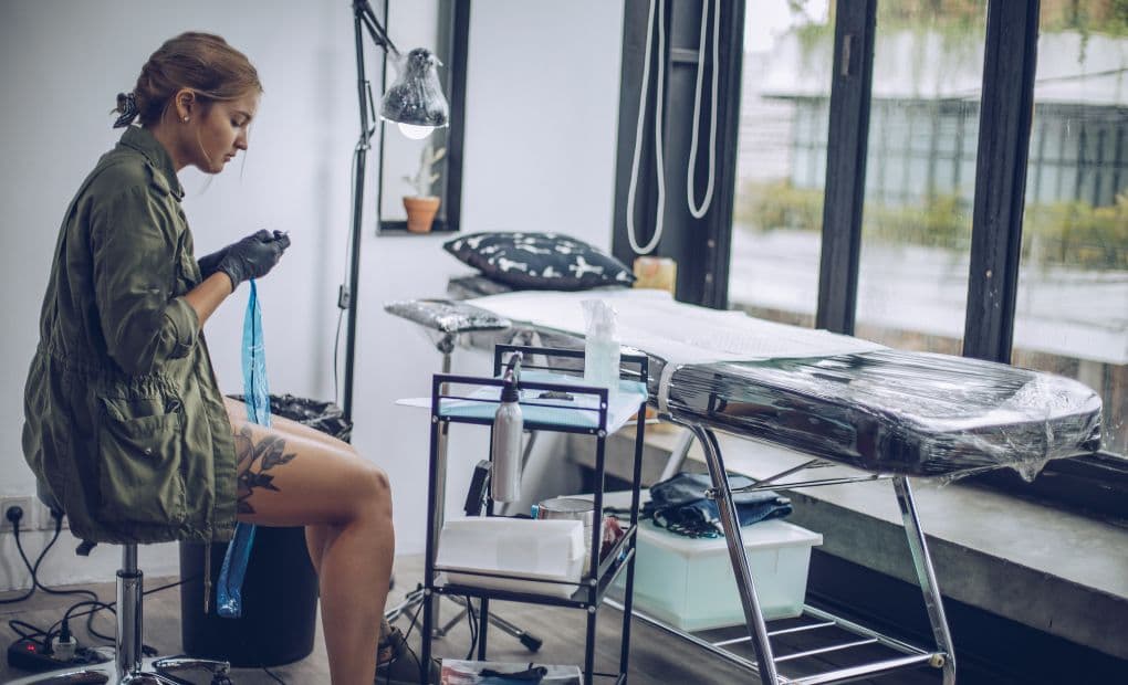 tattoo artist preparing at the side of the chair